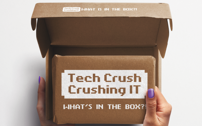 Eine Box von oben, die von zwei Händen geöffnet wird. Darauf steht: Tech Crush – Crushing IT.